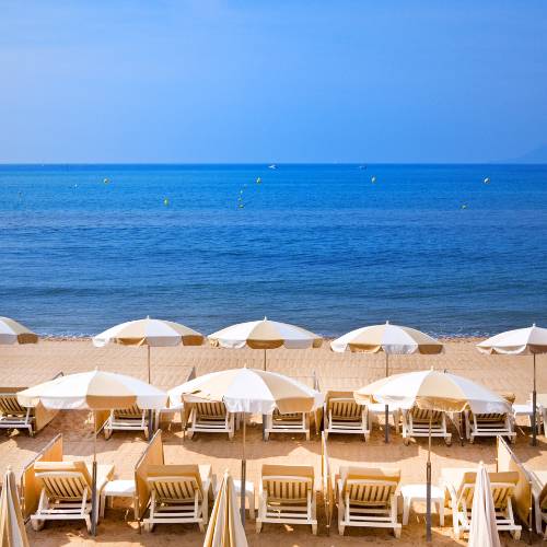 Vue d'une plage à Nice sur la Côte d'Azur avec des transats et des parasols